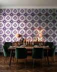 Pale Kilim Plum kilim wallpaper in a dark moody dining room with a candlelit table