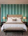 Parlor Stripe Emerald geometric stripe wallpaper behind the headboard of a king bed in a contemporary hotel guest room