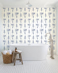 Petal & Thread Indigo botanical stem wallpaper behind a freestanding tub in a bright coastal bathroom