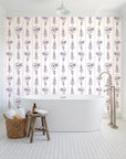 Petal & Thread Plum botanical stem wallpaper behind a freestanding tub in a bright coastal bathroom