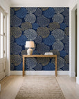 Petal Cascade Midnight spiral rosette wallpaper behind a console table in a light entry hallway