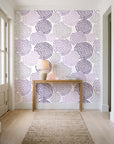 Petal Cascade Plum spiral rosette wallpaper behind a console table in a light entry hallway