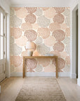 Petal Cascade Terracotta spiral rosette wallpaper behind a console table in a light entry hallway
