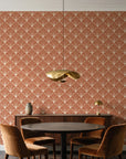 Petal Dawn Terracotta art deco fan wallpaper behind a walnut credenza and round table in an elegant dining room