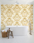 Petal Reflection Ochre floral damask wallpaper behind a freestanding tub in a bright coastal bathroom