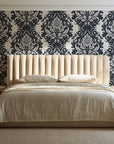 Poet's Blossom Charcoal classic damask wallpaper behind a channel-tufted bed in a calm primary bedroom