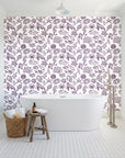 Quiet Reef Plum sea life wallpaper behind a freestanding tub in a bright coastal bathroom