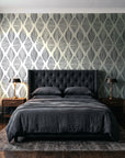 Reed & Smoke Ink geometric wallpaper behind a tufted headboard in a dark, moody bedroom