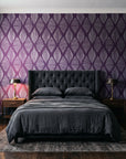 Reed & Smoke Plum geometric wallpaper behind a tufted headboard in a dark, moody bedroom