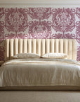 Serene Blossom Rose damask wallpaper behind a channel-tufted bed in a calm primary bedroom