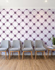 Shadow Garden Plum lattice floral wallpaper behind a row of upholstered chairs in a bright clinic waiting room