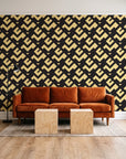 Signal & Edge Noir geometric wallpaper behind a rust velvet sofa in a bright coworking lounge