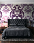 Silent Bouquet Plum damask wallpaper behind a tufted headboard in a dark, moody bedroom