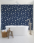 Sketched Seashells Midnight seashell wallpaper behind a freestanding tub in a bright coastal bathroom