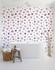 Sketched Seashells Plum seashell wallpaper behind a freestanding tub in a bright coastal bathroom