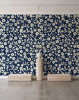 Sky Bloom Midnight floral wallpaper behind a travertine pedestal and vase in a minimal boutique