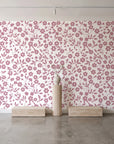 Sky Bloom Rose floral wallpaper behind a travertine pedestal and vase in a minimal boutique