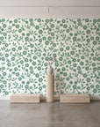 Sky Bloom Sage floral wallpaper behind a travertine pedestal and vase in a minimal boutique