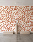Sky Bloom Terracotta floral wallpaper behind a travertine pedestal and vase in a minimal boutique