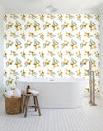 Sky Memory Saffron watercolor floral wallpaper behind a freestanding tub in a bright coastal bathroom