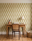 Smoke Ancestry Ochre geometric wallpaper behind a vintage writing desk in a cozy craft-room home office
