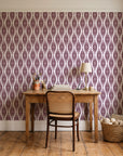 Smoke Ancestry Oxblood geometric wallpaper behind a vintage writing desk in a cozy craft-room home office
