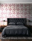 Solar Ritual Rosewood floral wallpaper behind a tufted headboard in a dark, moody bedroom