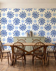 Solstice Bloom Cobalt folk sun wallpaper in a farmhouse dining room with a sage sideboard and rustic trestle table