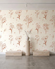Stardust Field Terracotta wildflower line art wallpaper behind a travertine pedestal and vase in a minimal boutique