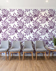 Starfall Plum watercolor leaf wallpaper behind a row of upholstered chairs in a bright clinic waiting room