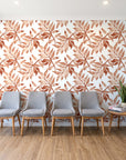 Starfall Terracotta watercolor leaf wallpaper behind a row of upholstered chairs in a bright clinic waiting room