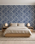 Still Labyrinth Navy maze geometric wallpaper behind a low platform bed in a serene Japandi bedroom