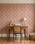Still Labyrinth Terracotta maze geometric wallpaper behind a vintage writing desk in a cozy craft-room home office