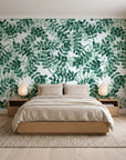 Still Morning Emerald foliage wallpaper behind a low platform bed in a serene Japandi bedroom