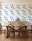 Stone Garden Navy sprig wallpaper in a farmhouse dining room with a sage sideboard and rustic trestle table
