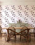 Stone Garden Oxblood sprig wallpaper in a farmhouse dining room with a sage sideboard and rustic trestle table