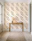 Stone Garden Terracotta sprig wallpaper behind a console table in a light entry hallway