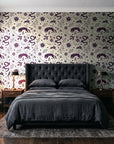 Sun & Moon Parchment celestial folk wallpaper behind a tufted headboard in a dark, moody bedroom