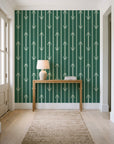 Tranquility Tapestry Emerald art deco stripe wallpaper behind a console table in a light entry hallway