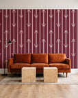 Tranquility Tapestry Oxblood art deco stripe wallpaper behind a rust velvet sofa in a bright coworking lounge
