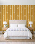 Tranquility Tapestry Saffron art deco stripe wallpaper behind a queen bed in a bright coastal bedroom