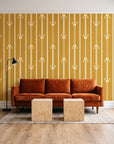Tranquility Tapestry Saffron art deco stripe wallpaper behind a rust velvet sofa in a bright coworking lounge