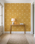 Tranquility Tapestry Saffron art deco stripe wallpaper behind a console table in a light entry hallway