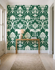 Twilight Garden Veil Emerald damask wallpaper behind a console table in a light entry hallway