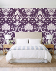 Twilight Garden Veil Plum damask wallpaper behind a queen bed in a bright coastal bedroom