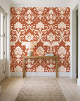 Twilight Garden Veil Terracotta damask wallpaper behind a console table in a light entry hallway
