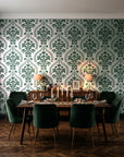 Veiled Botany Sage damask wallpaper in a dark moody dining room with a candlelit table