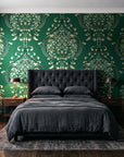 Vintage Eden Emerald damask wallpaper behind a tufted headboard in a dark, moody bedroom
