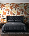 Winter Forage Terracotta pine bough and berry wallpaper behind a tufted headboard in a dark, moody bedroom