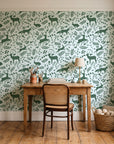 Woodland Hush Sage woodland animal wallpaper behind a vintage writing desk in a cozy craft-room home office